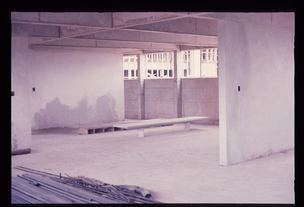 Descrição gerada por inteligência artificial: Imagem de concreto, paredes, janelas, banco, barras, piso, teto