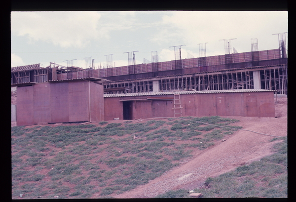 Descrição gerada por inteligência artificial: Imagem de prédios, grama, escada, céu, estrutura, construção, terra